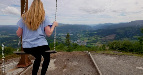 Girl swinging while overlooking the landscape from Hangurstoppen mountains photo