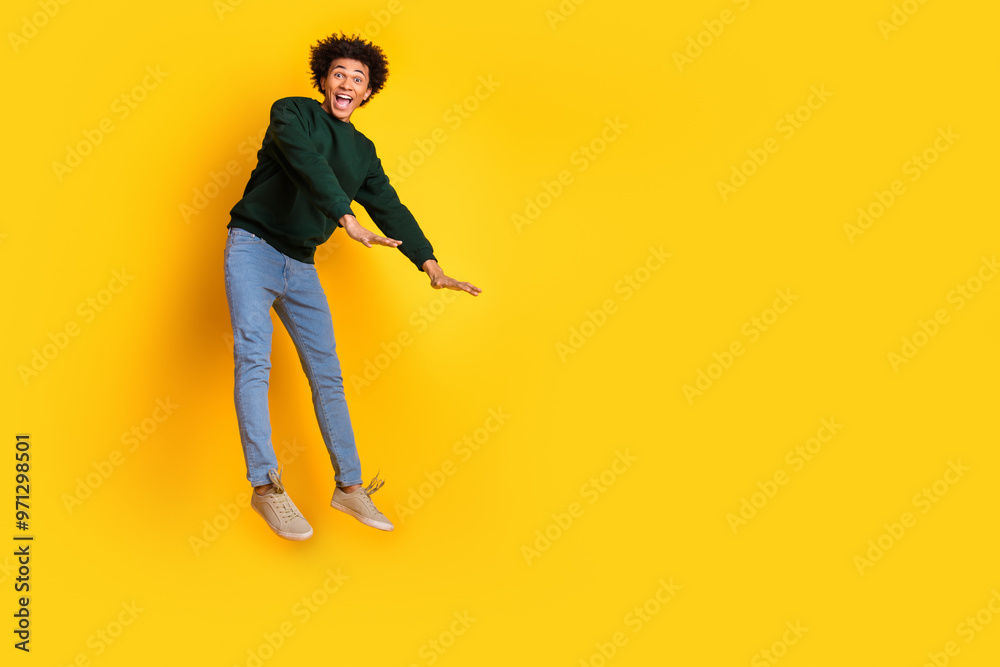 Full body portrait of nice young man jump fall empty space wear sweater isolated on yellow color background Full body portrait of nice young man jump fall empty space wear sweater isolated on yellow color background