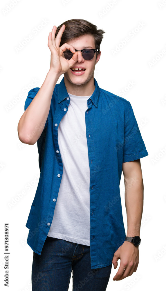 Young handsome man wearing sunglasses over isolated background doing ok gesture with hand smiling, eye looking through fingers with happy face.