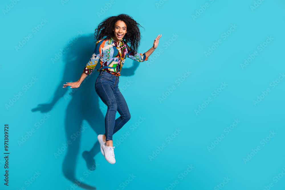 Photo of cheerful glad nice girl wear trendy clothes fly air empty space isolated on blue color background Photo of cheerful glad nice girl wear trendy clothes fly air empty space isolated on blue color background