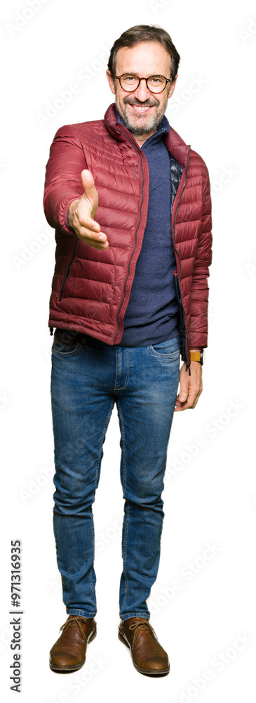 Obraz premium Middle age handsome man wearing glasses and winter coat smiling friendly offering handshake as greeting and welcoming. Successful business.