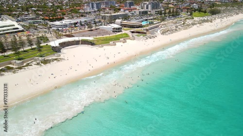Drone over the vibrant turquoise waters of Scarborough Beach with white sand and coastal buildings photo