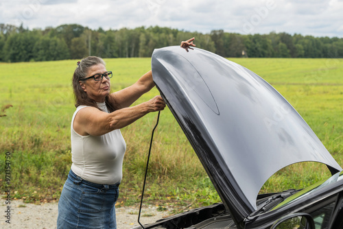 Obraz na płótnie Frau öffnet die Motorhaube ihres Autos w salonie