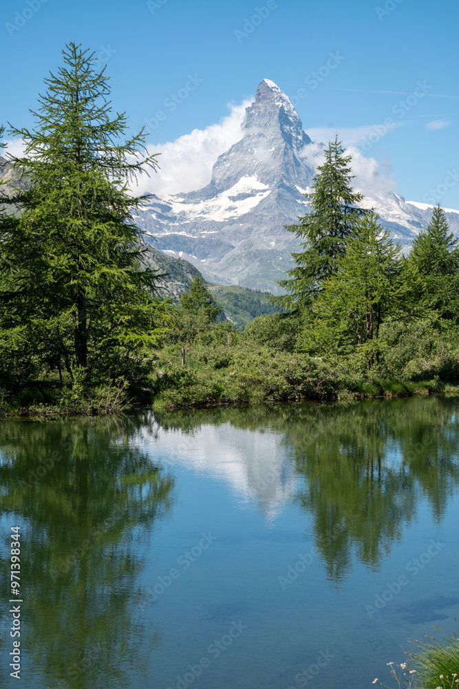 Grindjisee lake located on the famous Zermatt trail - Five Lakes hike. Matterhorn Peak visible on the horizon and reflecting in the lake, Switzerland Grindjisee lake located on the famous Zermatt trail - Five Lakes hike. Matterhorn Peak visible on the horizon and reflecting in the lake, Switzerland