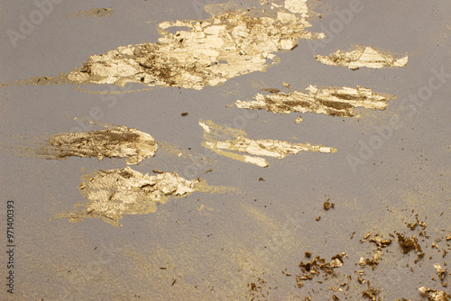 Golden shiny paper texture with glowing sparkles on beige watercolor background