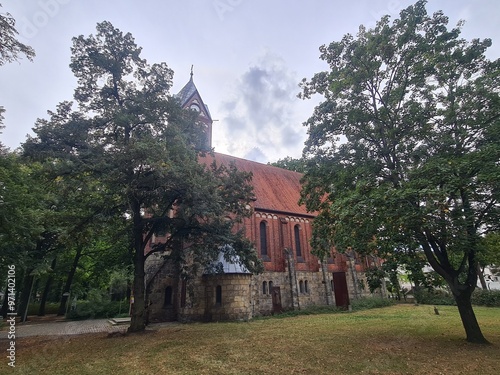 eine Landschaft mit einer von Bäumen verdeckten Kirche in Berlin Grünau photo