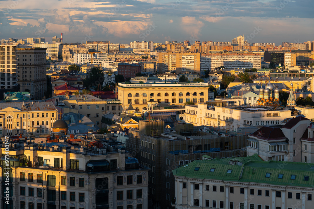 Fototapeta premium High angle panoramic cityscape of downtown district with residential, office and religious buildings at sunset in Moscow, Russia. Clouds on sky. Soft focus. Capital cities theme.