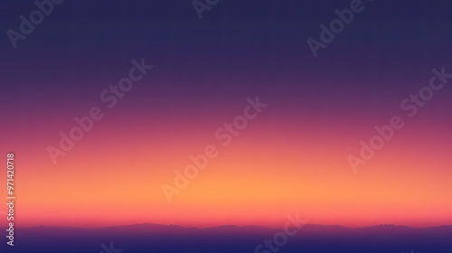 A serene gradient sunset over distant mountains, showcasing a blend of colors in the sky.