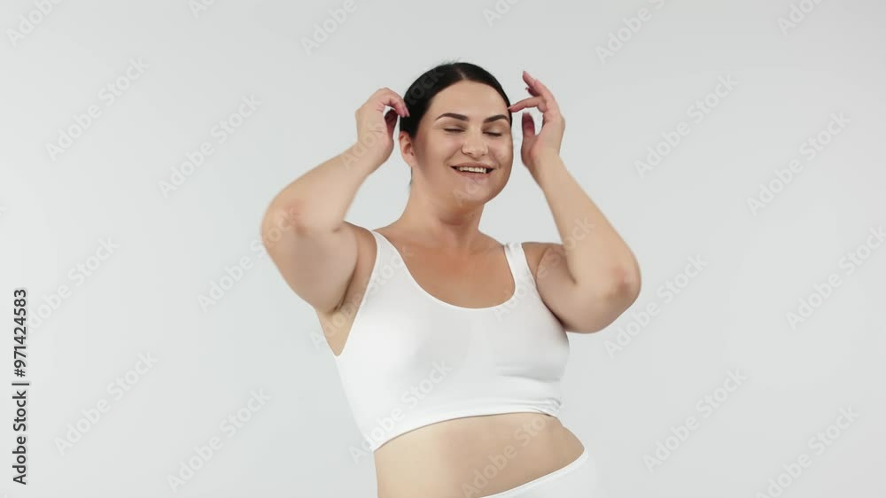 Full-figured young woman posing on a white studio background, exuding confidence and positivity. Perfect for promoting body positivity, fashion, and self-confidence, inspiring self-acceptance.