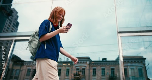 Beautiful young woman student with coffee and phone outdoors. College student walking in university campus