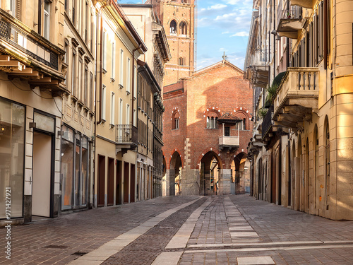 Fototapeta Naklejka Na Ścianę i Meble -  A pedestrian street with unmarked shops and no people leads to the 13th-century medieval palace known as the Arengario in the centre of Monza