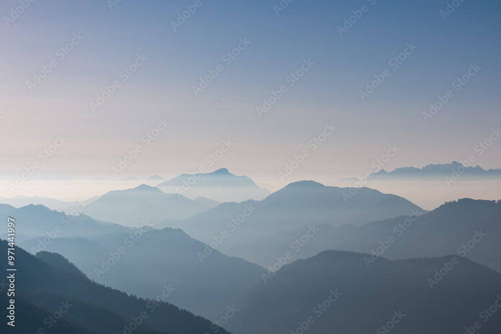 Fototapeta premium Serene alpine landscape at dawn in Gailtal Alpen, Carinthia, Austria, Europe. Silhouette of majestic hazy mountain ridges of Julian Alps. Peaceful tranquil atmosphere in Austrian Alps. Wanderlust