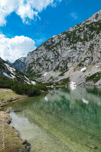 Panoramic view of serene alpine lake Hölltalsee (Silberkarsee) surrounded by majestic mountain ridges in Schladming, Styria, Austria. Hiking trail in Austrian Alps in spring. Schladminger Tauern photo