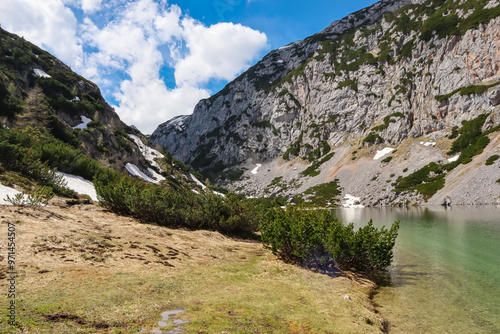 Panoramic view of serene alpine lake Hölltalsee (Silberkarsee) surrounded by majestic mountain ridges in Schladming, Styria, Austria. Hiking trail in Austrian Alps in spring. Schladminger Tauern photo