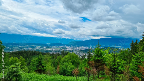 Panoramic aerial view of the city of Villach surrounded by majestic mountain ranges of Julian Alps and Karawanks, Carinthia, Austria, Europe. Idyllic forest walk near the Landskron Castle. Cityscape. photo