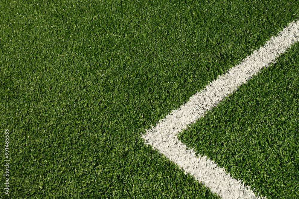 Fototapeta premium Artificial green grass with white stripe of soccer field. Outdoors. Summer. View from above.