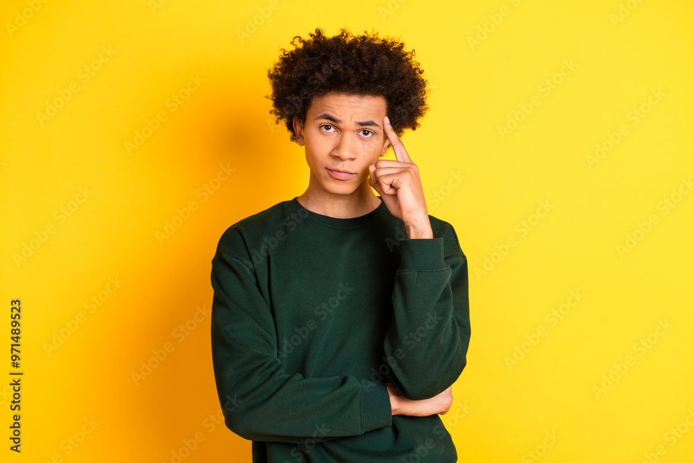 Portrait of nice young man finger touch temple think wear sweater isolated on yellow color background Portrait of nice young man finger touch temple think wear sweater isolated on yellow color background
