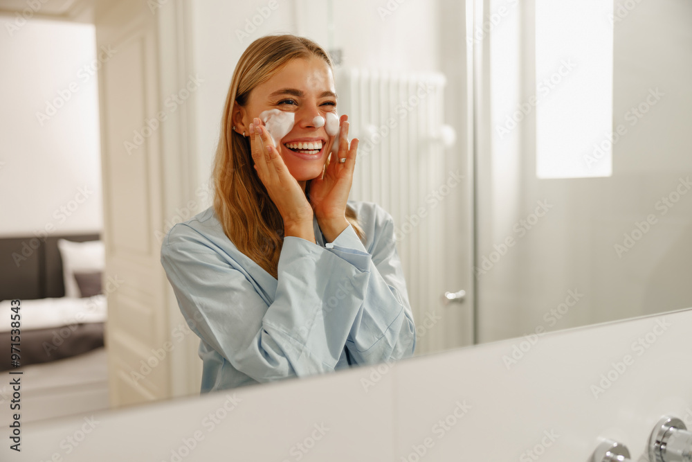 A joyful woman applies her favorite skincare product in the mirror, promoting selfcare, beauty, and wellness A joyful woman applies her favorite skincare product in the mirror, promoting selfcare, beauty, and wellness