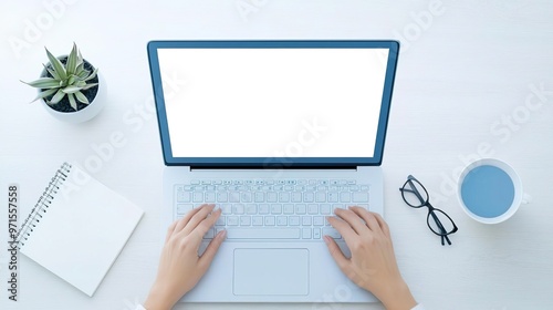 Top view of a person working on a laptop with a blank screen.