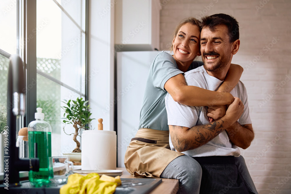 Happy couple in love relaxing after washing dishes together. Happy couple in love relaxing after washing dishes together.