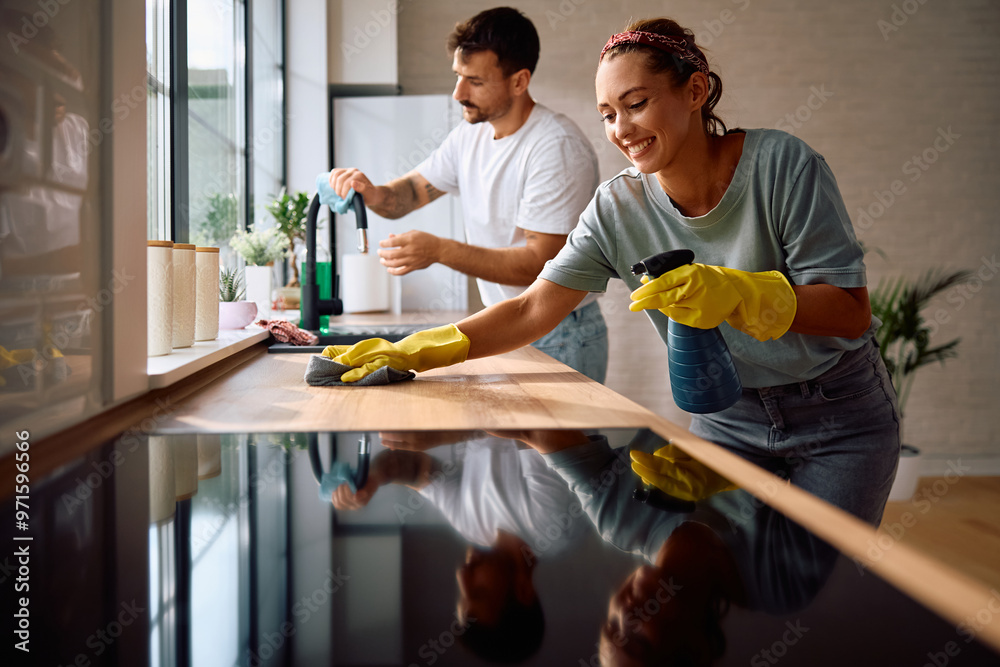 © Drazen - Happy woman cleaning kitchen with her boyfriend. © Drazen - Happy woman cleaning kitchen with her boyfriend.