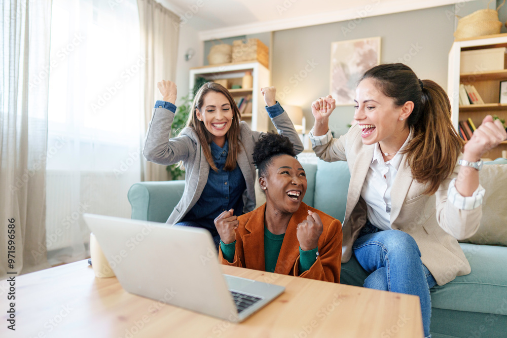 Joyful Friends Celebrating Victory with Laptop at Home Joyful Friends Celebrating Victory with Laptop at Home