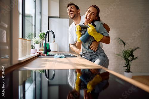 Fotografie Carefree couple laughing and having fun while doing housework together