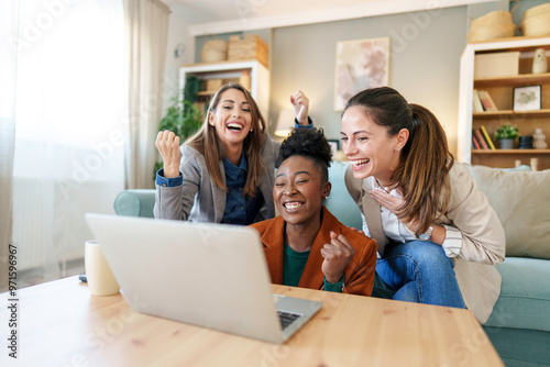 Joyful Friends Sharing Laptop Moment in Home Setting