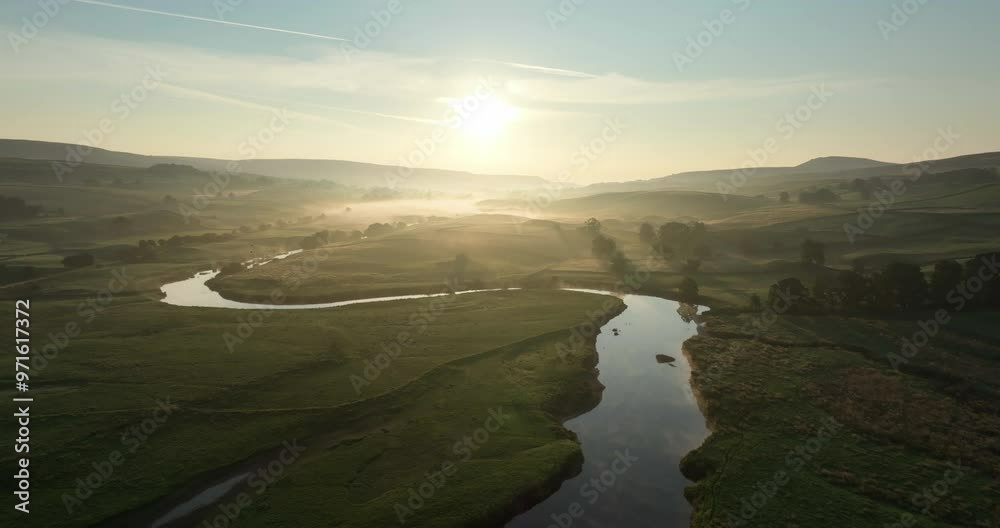 Flying over calm river in a misty valley