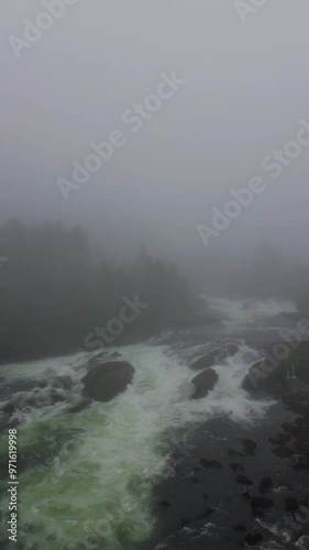 A breathtaking misty river scene showcasing flowing water accompanied by enchanting fog In Norway