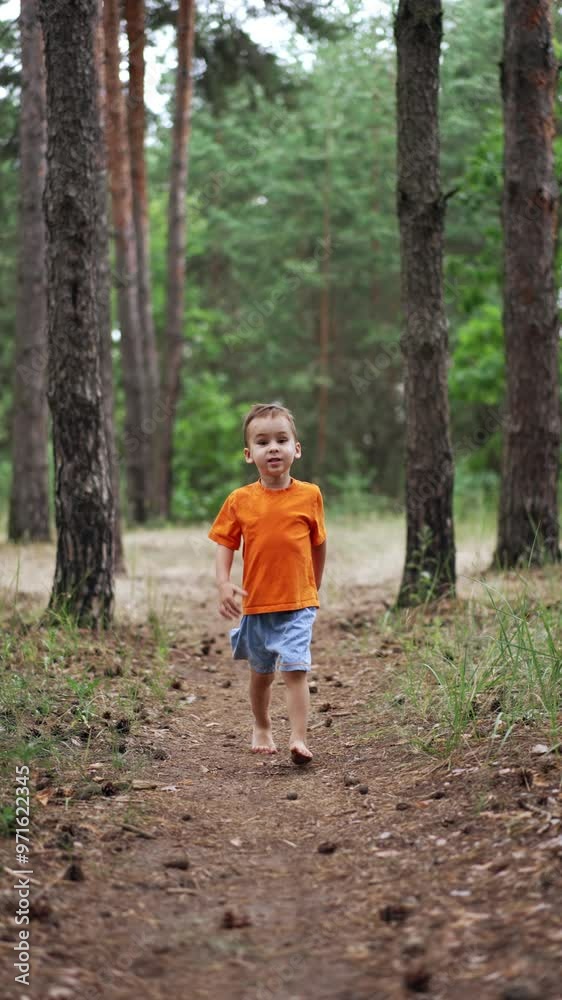 Kid runs barefoot by the forest path with lots of pine cones on. Healthy growing up in connection with nature. Vertical video.