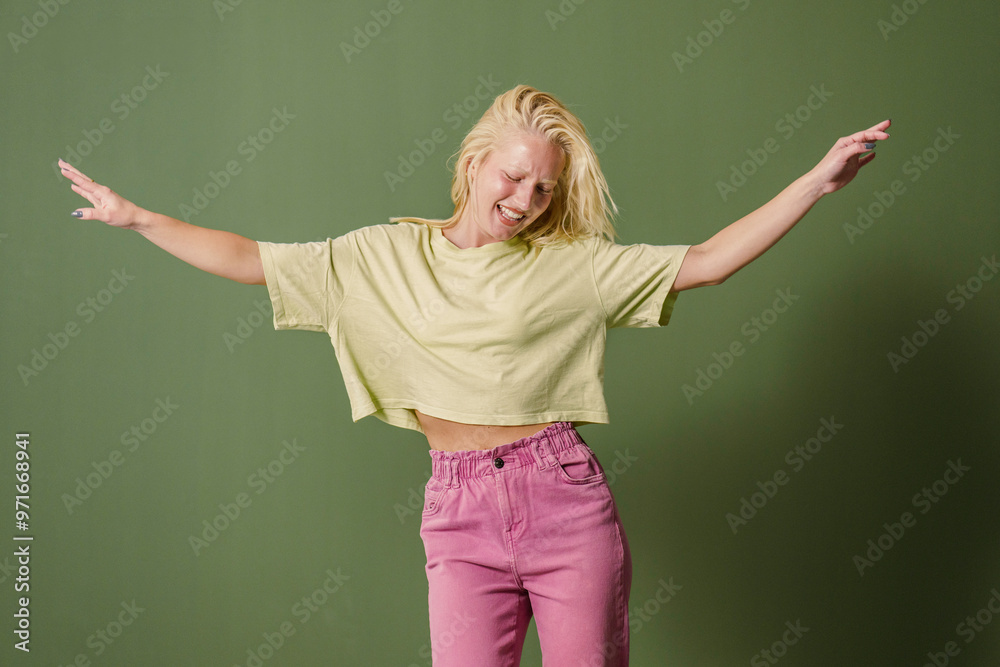 Joyful Young Woman Dancing Solo on Green Backdrop Joyful Young Woman Dancing Solo on Green Backdrop