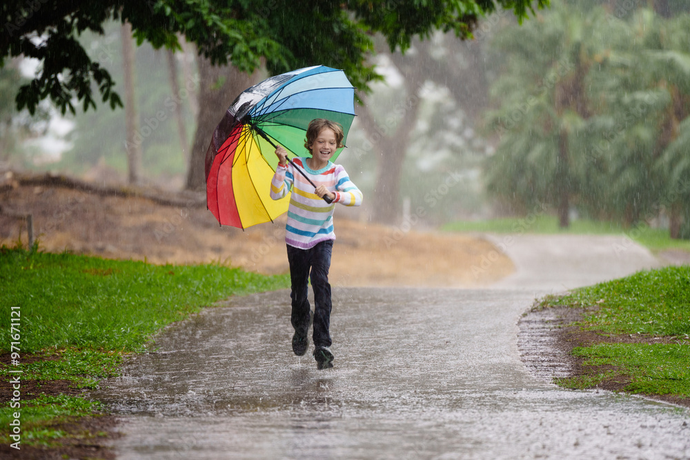 Child playing in rain. Kid jumping in puddle. Child playing in rain. Kid jumping in puddle.