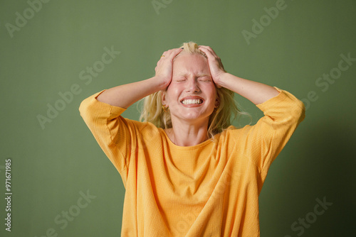 Stressed Young Woman on Green Background