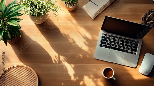 Aerial view of modern office desk with laptop, coffee and decorative plants. photo