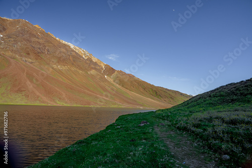 Chandratal lake, Moon Lake during Sunset with crystal clear water in between mountains surrounded by snowcapped mountains. photo