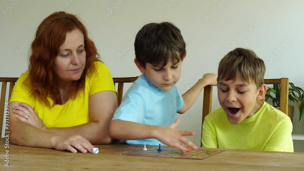 Mother plays with sons, time together with board games Mother plays with sons, time together with board games
