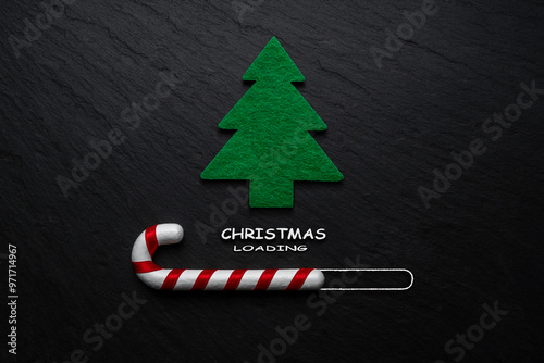 Creative layout made of Candy cane with Christmas tree on black stone background. Minimal Christmas loading concept. photo