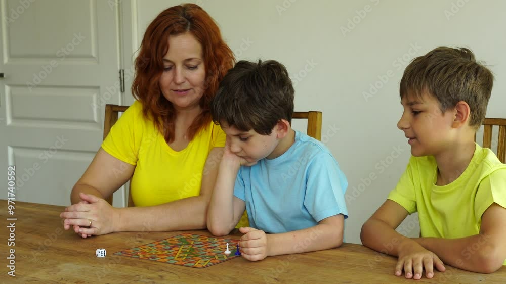 Mother plays with sons, time together with board games Mother plays with sons, time together with board games