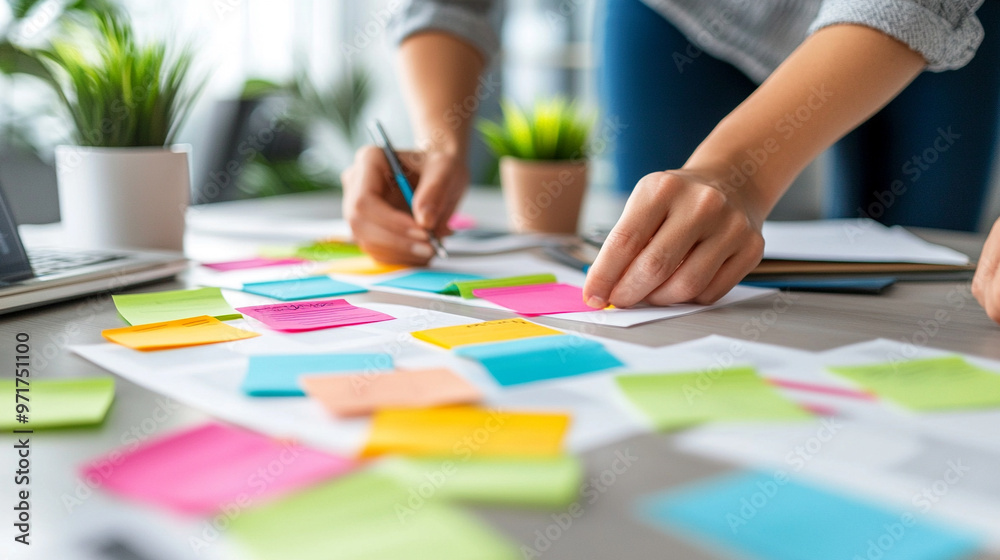 collaborative team working together around a table, hands visible, using sticky notes to brainstorm ideas. The scene emphasizes teamwork, creativity, and problem-solving