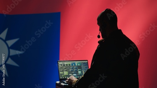 Taiwanese insurgent uses laptop to combat Chinese mass propaganda promoting One China policy, engaging in psychological operations. Taiwan spy defends against CCP PsyOp sabotage using device, camera A