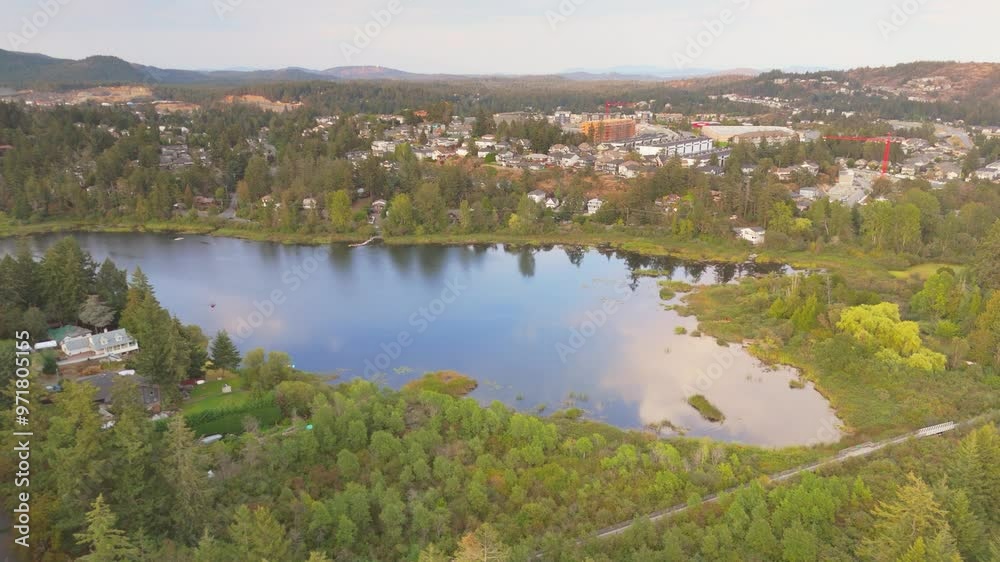 Aerial view of a serene lake surrounded by lush greenery and a small town Aerial view of a serene lake surrounded by lush greenery and a small town