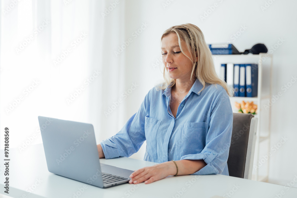 Business woman blonde working with laptop online in white office Business woman blonde working with laptop online in white office