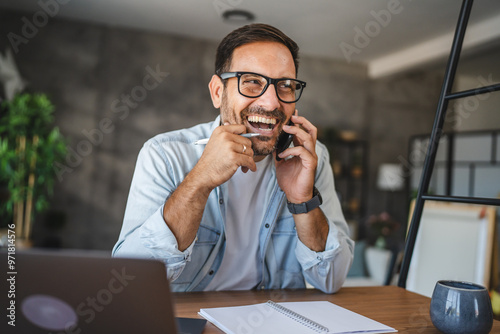 Adult man smile and enjoy while talk on mobile phone at home