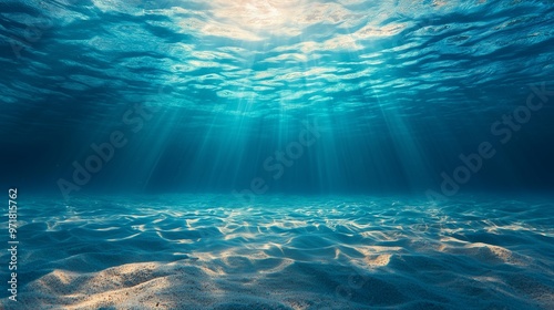 Underwater background deep blue sea and beautiful light rays with sandy floor.