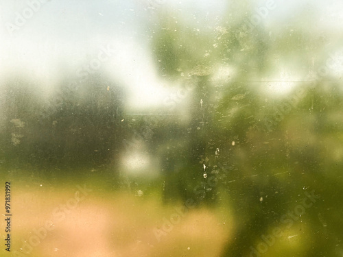 Abstract blurred nature scene through a dusty glass window. Perfect for background textures and artistic designs
