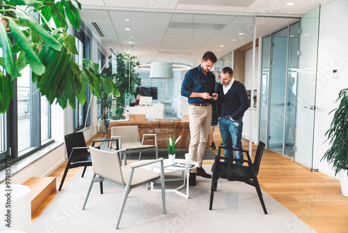 Two colleagues discussing data while looking at a digital tablet