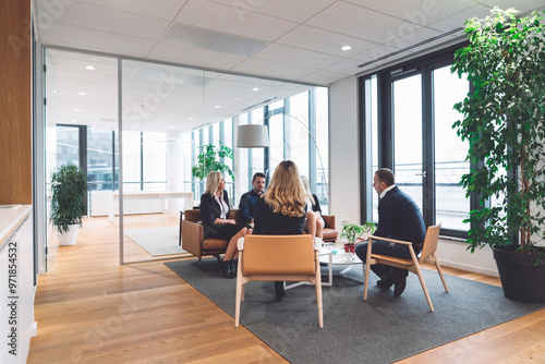 Business people having a casual meeting in modern office lounge