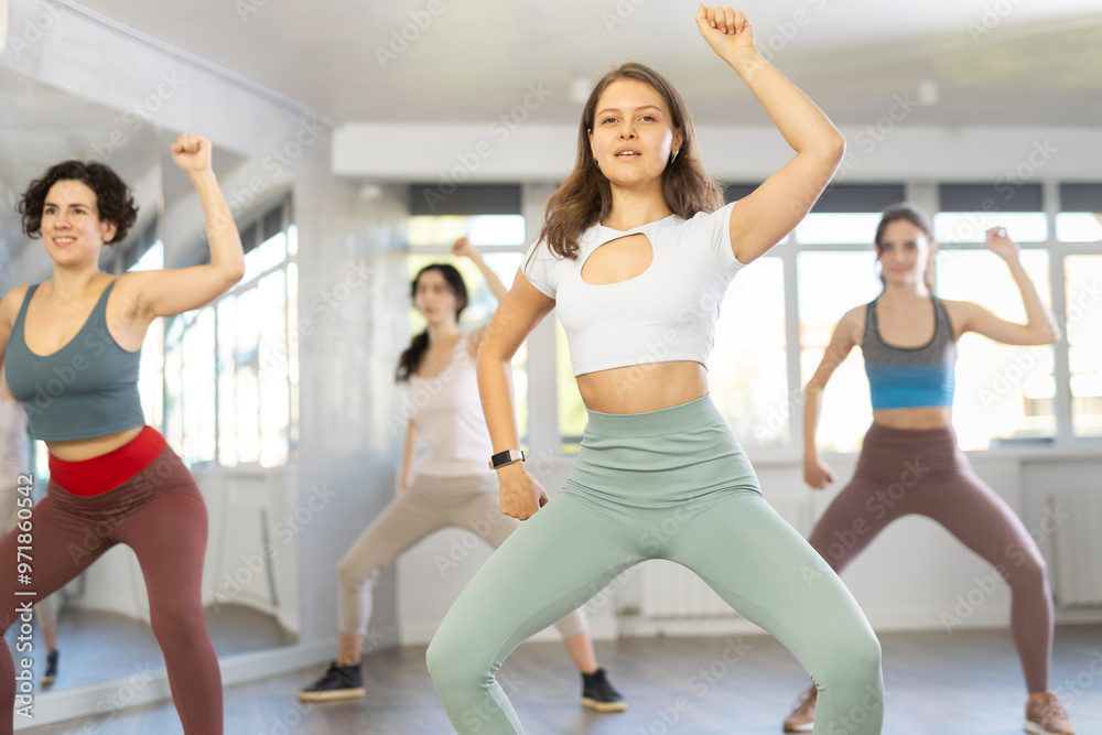 Fototapeta premium Group of women learning modern dance movements at class together