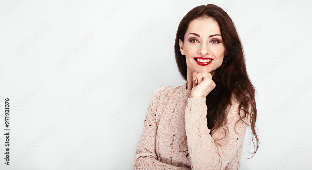 Happy make-up brunette woman with red lipstick looking happy in beige blouse with hand under the face on empty copy space studio wall isolated background. Portrait banner